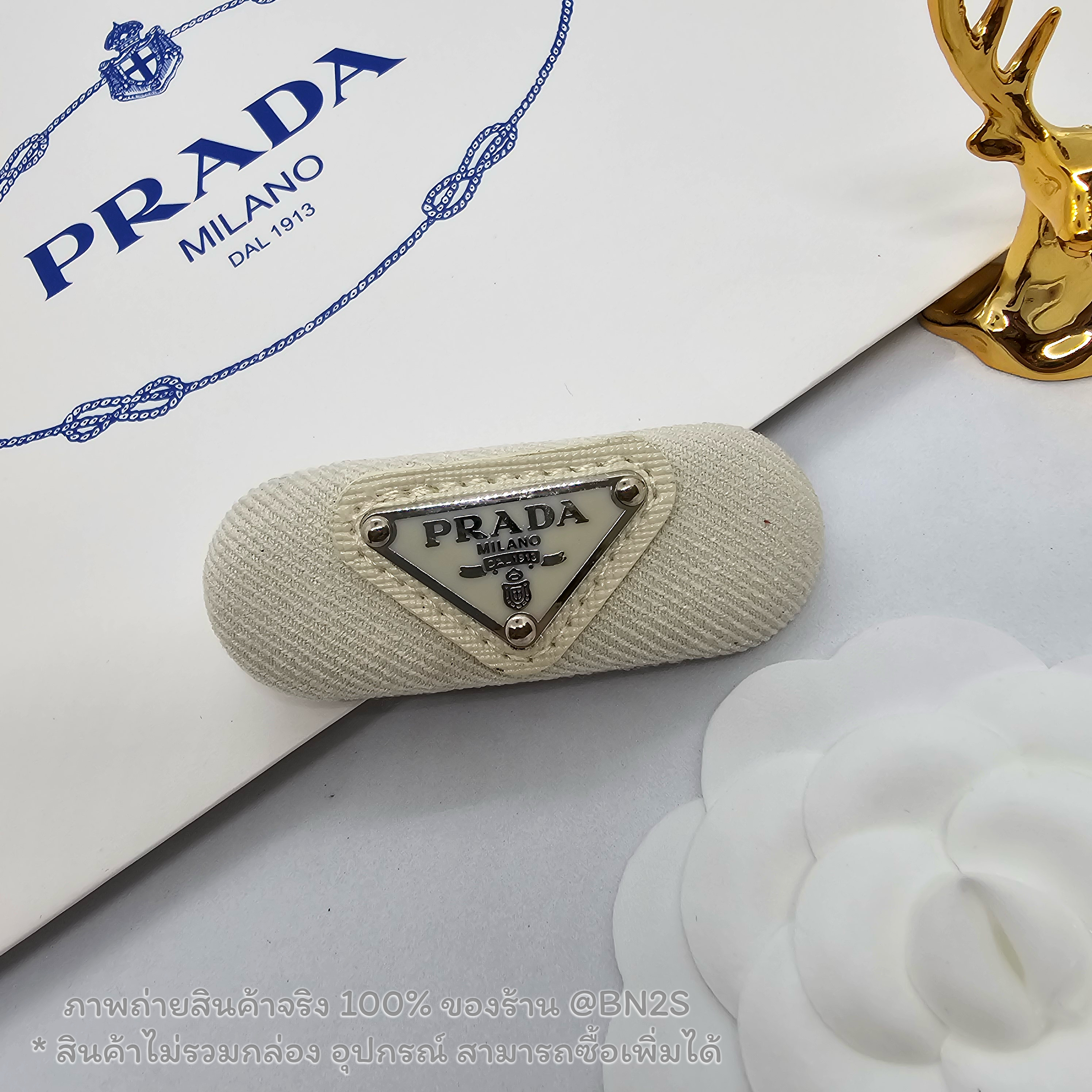 สีขาว | กิ๊บหนีบผมปราด้า แบบสปริง รุ่น PRADA Enamel-logo hair clip ตัวหนีบสปริงติดโลโก้เพลท ตัวงานเป็นผ้าโลโก้วงรี ภาพถ่ายงานจริง
