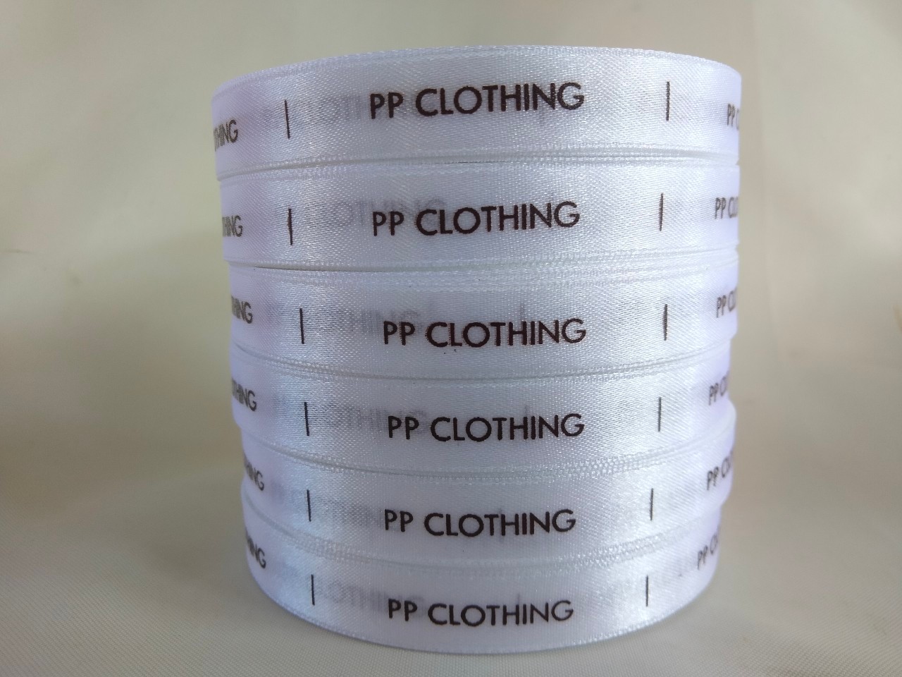 ป้ายคอเสื้อ เนื้อริบบิ้นซาติน 1.3 ซม. ริบบิ้นสีขาว 1 พิมพ์น้ำตาล 5 ม้วน