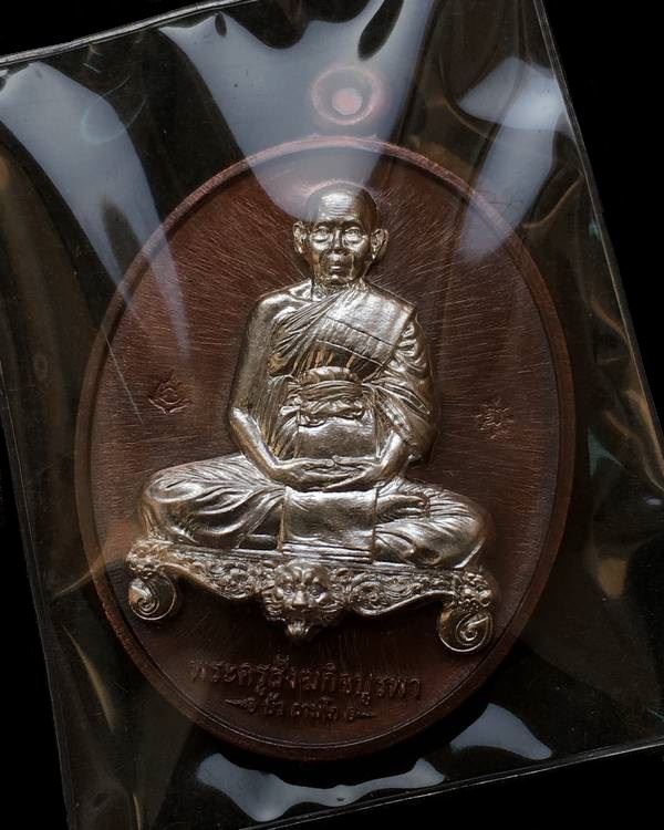 เหรียญนั่งโต๊ะพิมพ์เต็มองค์ หลวงปู่บัว ถามโก วัดศรีบุรพาราม รุ่นมงคลมหาลาภ ปี ๒๕๕๙ เนื้อนวโลหะ หน้ากากเงิน หมายเลข ๘๗๗