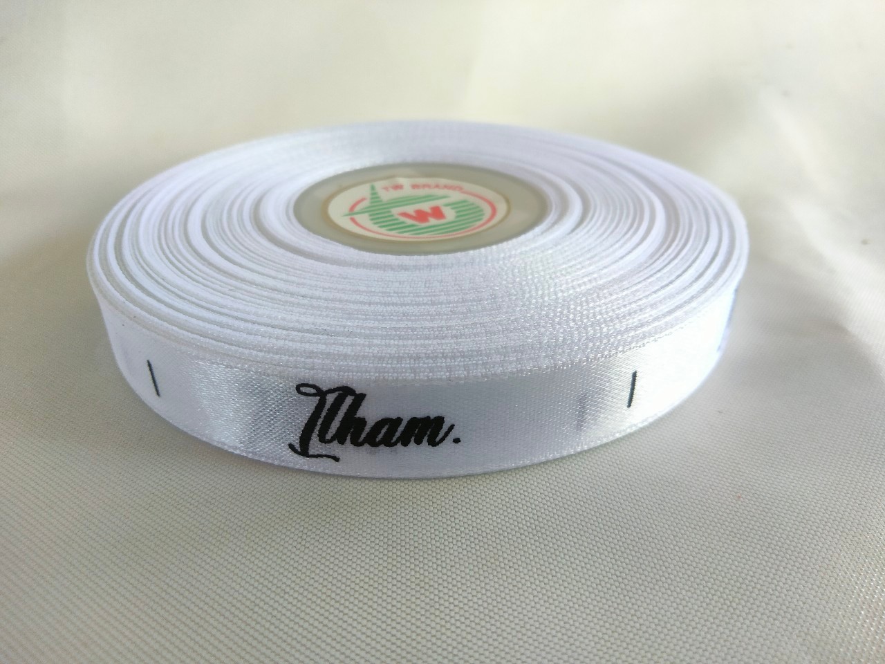 ป้ายคอเสื้อ เนื้อริบบิ้นซาติน 1.3 ซม. ริบบิ้นสีขาว พิมพ์ดำ 1 ม้วน