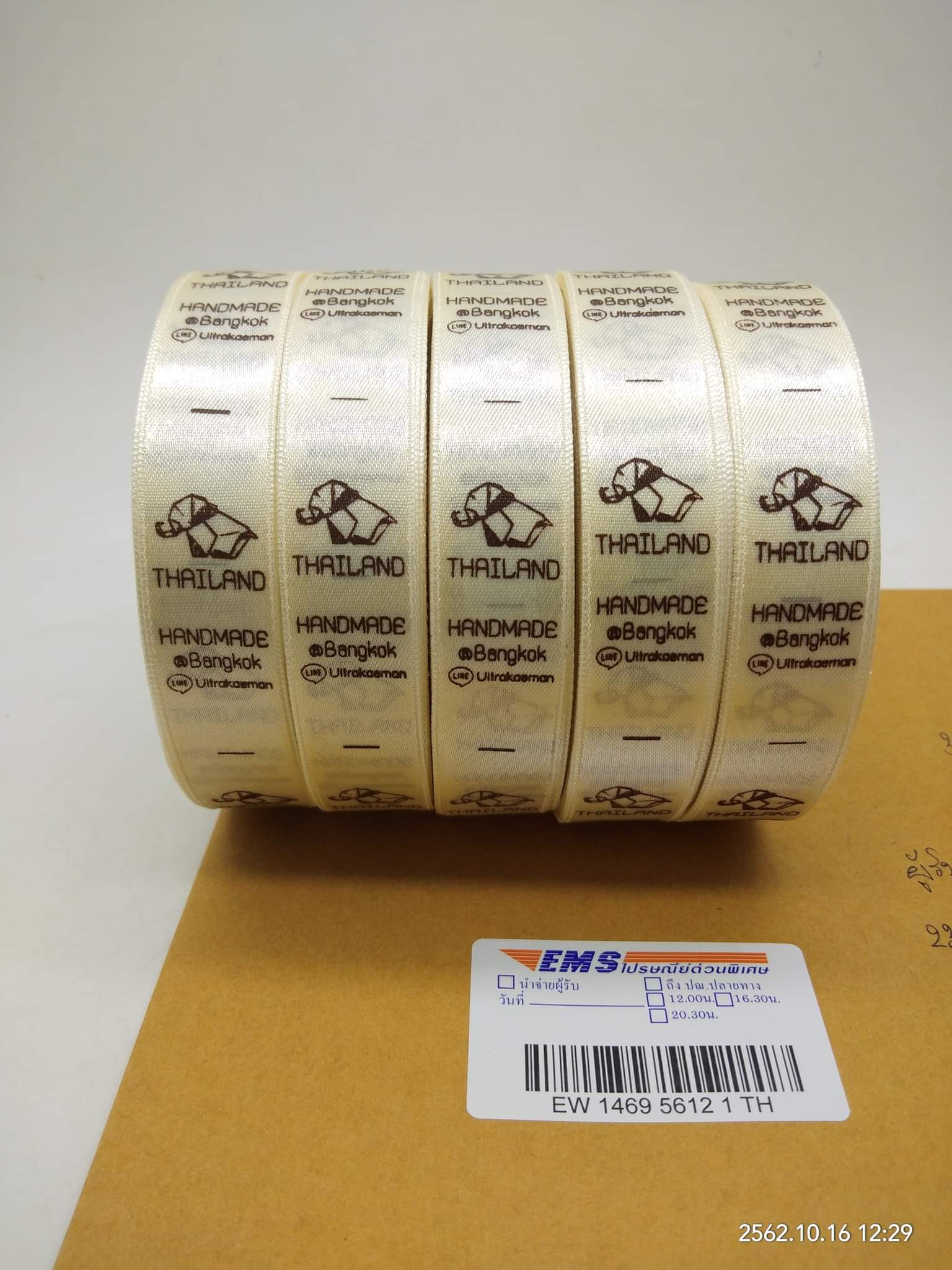 ป้ายคอเสื้อ เนื้อริบบิ้นซาติน 2 ซม. ริบบิ้นสีครีม S-2 พิมพ์น้ำตาล 5 ม้วน