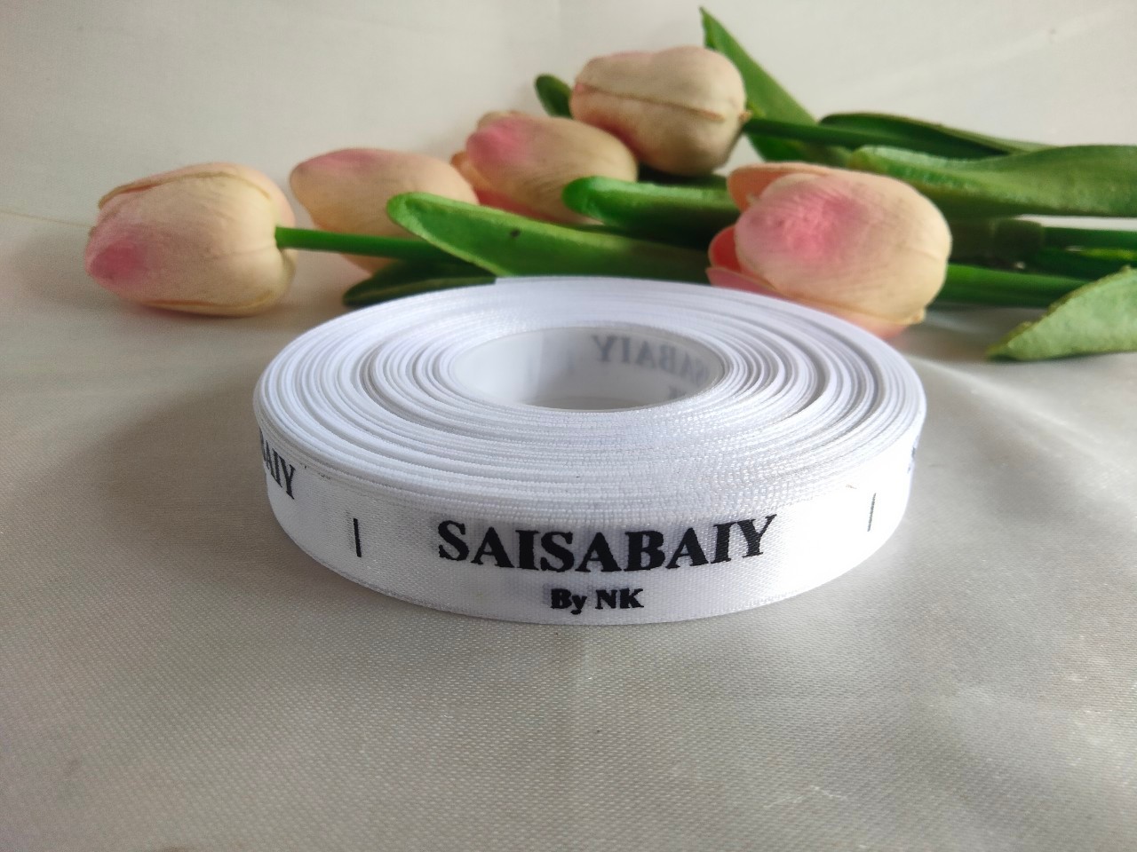 ป้ายคอเสื้อ เนื้อริบบิ้นซาติน 1.3 ซม. ริบบิ้นสีขาว 1 พิมพ์ดำ 1 ม้วน