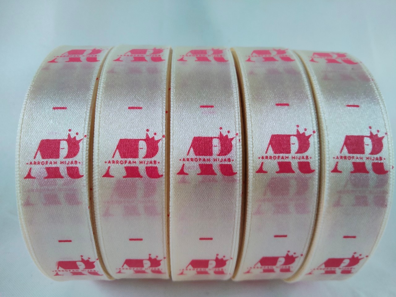ป้ายคอเสื้อ เนื้อริบบิ้นซาติน 2 ซม. ริบบิ้นสีครีม S-2 พิมพ์ชมพู 5 ม้วน