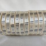 ป้ายคอเสื้อ เนื้อริบบิ้นซาติน 1.3 ซม. ริบบิ้นสีครีม S-2 พิมพ์ดำ 12 ม้วน