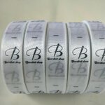 ป้ายคอเสื้อ เนื้อริบบิ้นซาติน 2.0 ซม. ริบบิ้นสีขาว 1 พิมพ์ดำ 5 ม้วน