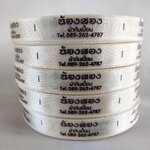 ป้ายคอเสื้อ เนื้อริบบิ้นซาติน 1.3 ซม. ริบบิ้นสีครีม S-2 พิมพ์น้ำตาล 5 ม้วน