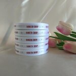 ป้ายคอเสื้อ เนื้อริบบิ้นซาติน 1.3 ซม. ริบบิ้นสีขาว 1 พิมพ์น้ำตาลทอง 5 ม้วน