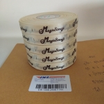 ป้ายคอเสื้อ เนื้อริบบิ้นซาติน 1.3 ซม. ริบบิ้นสีครีม S-2 พิมพ์น้ำตาล 5 ม้วน