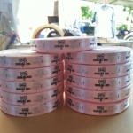 ป้ายคอเสื้อ เนื้อริบบิ้นซาติน 1.3 ซม. ริบบิ้นสีชมพู 64a พิมพ์ดำ 11 ม้วน