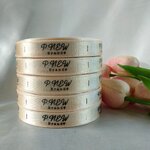 ป้ายคอเสื้อ เนื้อริบบิ้นซาติน 1.3 ซม. ริบบิ้นสีทองอ่อน 61 พิมพ์ดำ 5 ม้วน