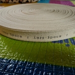 ป้ายคอเสื้อ เนื้อคอตต้อนก้างปลา 2.0 ซม.พิมพ์ดำ 1 ม้วน