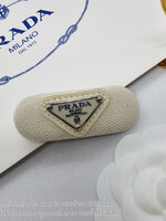 สีขาว | กิ๊บหนีบผมปราด้า แบบสปริง รุ่น PRADA Enamel-logo hair clip ตัวหนีบสปริงติดโลโก้เพลท ตัวงานเป็นผ้าโลโก้วงรี ภาพถ่ายงานจริง
