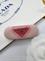 สีชมพู | กิ๊บหนีบผมปราด้า แบบสปริง รุ่น PRADA Enamel-logo hair clip ตัวหนีบสปริงติดโลโก้เพลท ตัวงานเป็นผ้าโลโก้วงรี ภาพถ่ายงานจริง